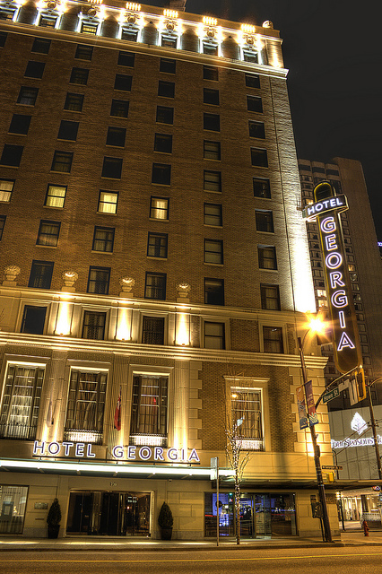 The front of a historic hotel at night. A neon sign says &quot;Hotel Georgia.&quot;