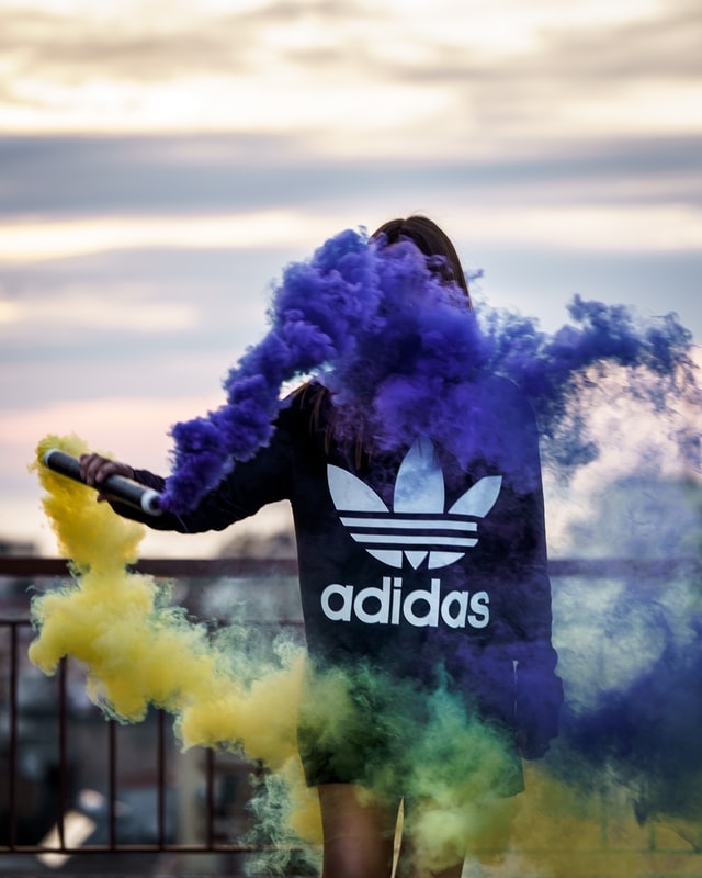 Image of a model representing adidas through colourful smoke.