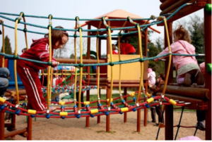 Children playing on a jungle gym at a park.