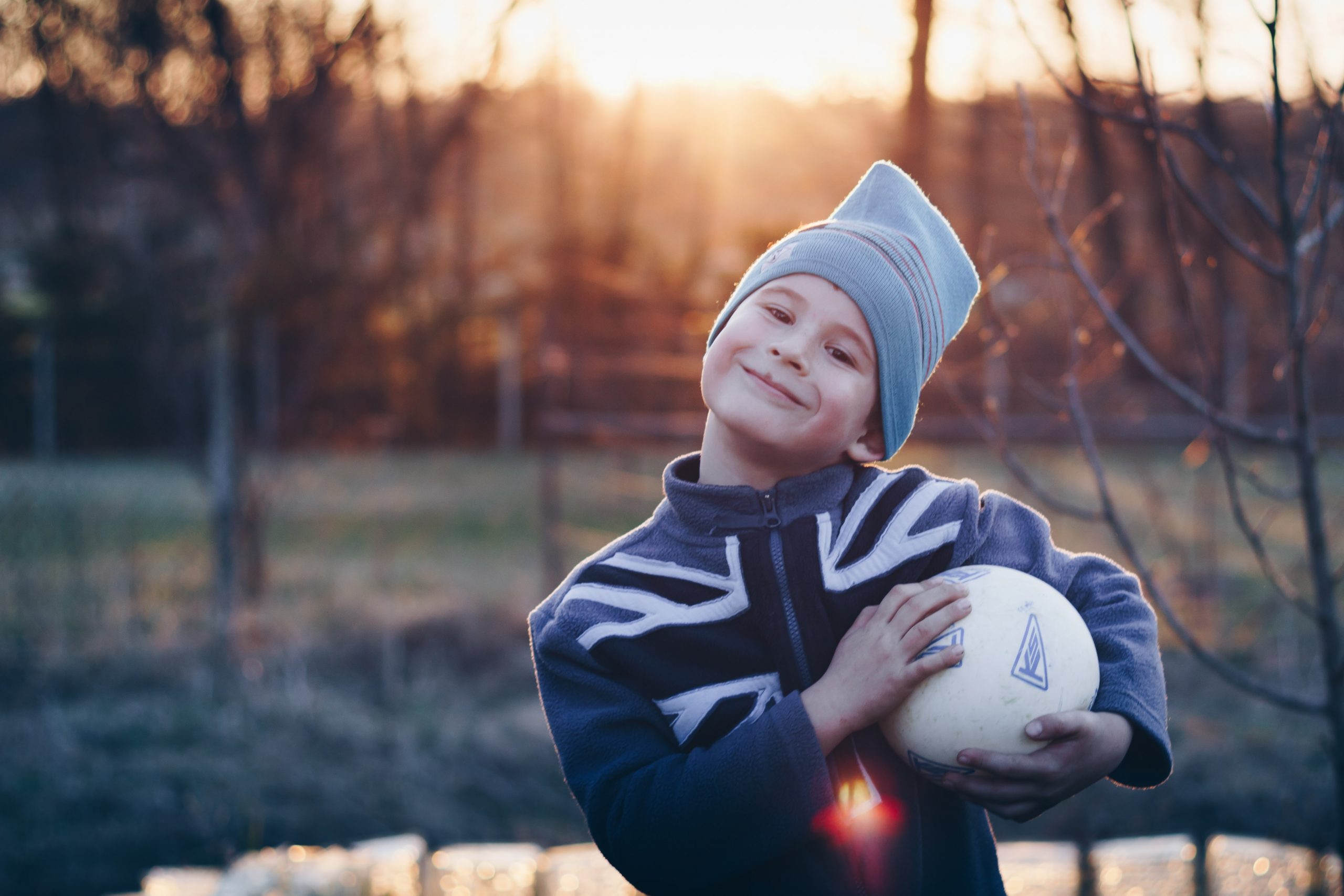 young boy proudly holding a soccer ball