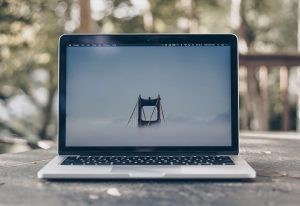 An open laptop with an image of a bridge on its home screen.