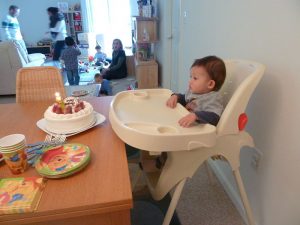 An infant sitting in a highchair.