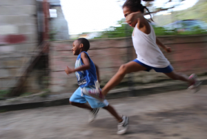 Two children running down the street in Carenage, Trinidad and Tobago.