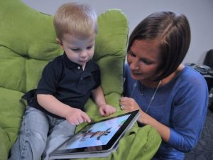 This mother is helping her son navigate using a tablet.