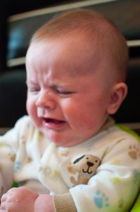 An infant making a sad facial expression