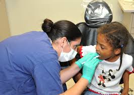 A dentist checking a child’s teeth.