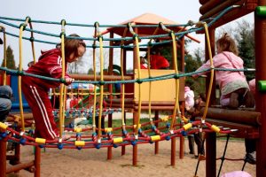Children playing on a jungle gym at a park.