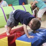 Toddler climbing on large, soft blocks