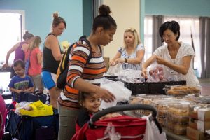 Moms and children selecting food from a food bank