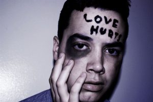 Young man with Love Hurts written on his forehead.