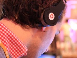 Side profile picture of a young man wearing Beats headphones