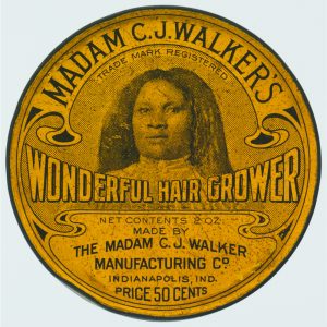 An aged lid of a hair care product featuring an image of the female founder surrounded by text.
