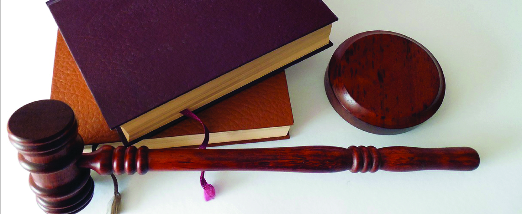 A judge's gavel rests next to two leather-bound books.