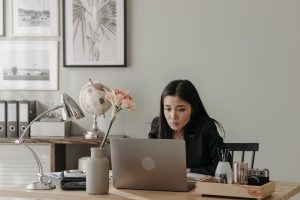 woman working on a laptop sitting at a desk.