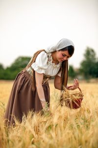 Woman picking grain in grain field