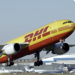 The image shows a DHL cargo plane on the tarmac at an airport