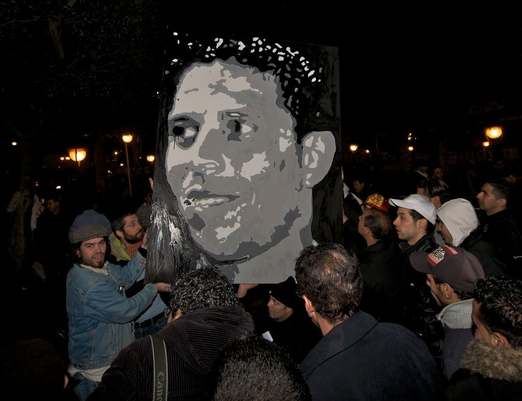 A group of people holding up an image of Mohamed Bouazizi.