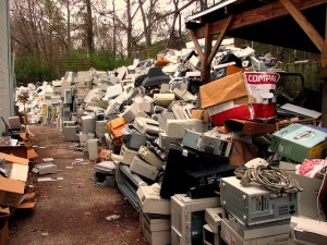 Piles of e-waste including computers and microwaves.