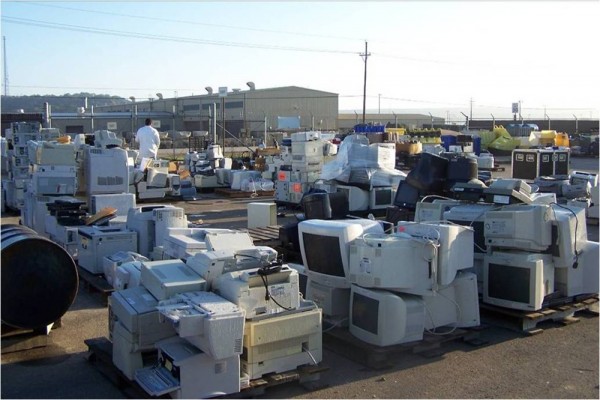 Piles of computer monitors, printers, microwaves, and hard drives.