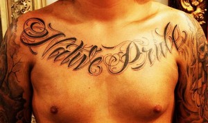 A chest tattoo spelling out "Native Pride."