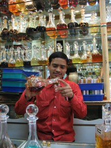 A boy pouring perfume into small bottles.