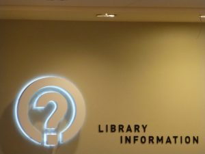 The front desk of the Berkeley Public Library with the text Library information, and a icon for a question mark surrounded by a circle.