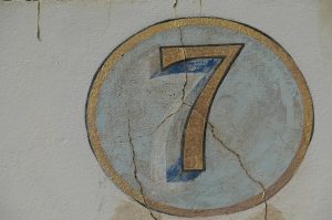 A handpainted gold number 7 with a light blue circle, and a gold border.