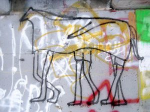 A Graffiti wall with a painting of three-person horse
