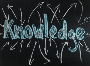 A blackboard with knowledge written in chalk with arrows radiating from it 